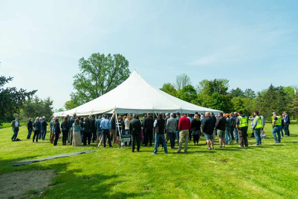 A large, white event tent with many people under it