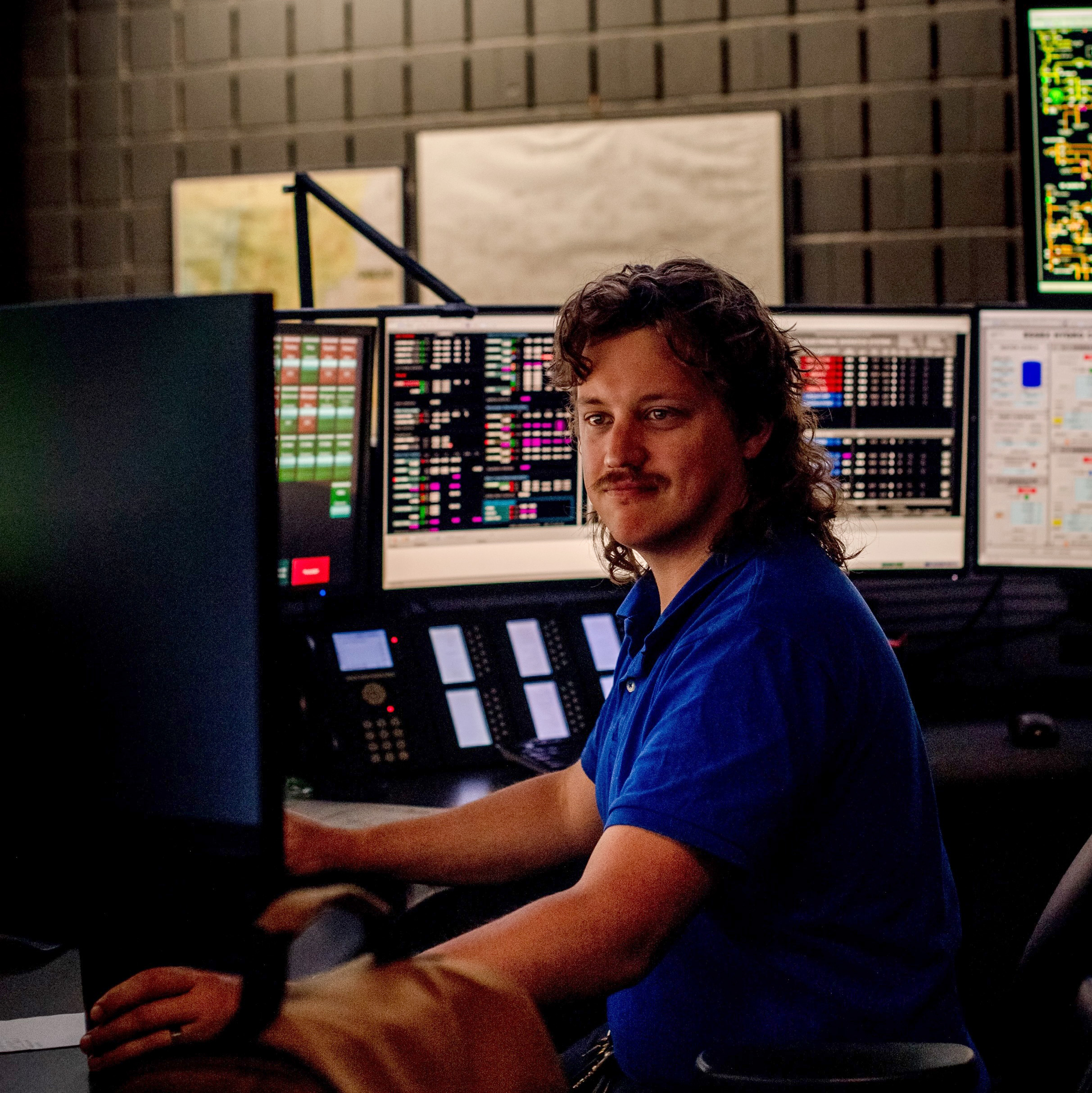 Logan in front of desk in the control center